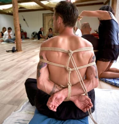 A rope harness tied across a participant’s back